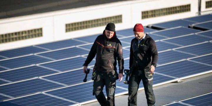 Två montörer från Solkompaniet går på tak med en solcellsanläggning
